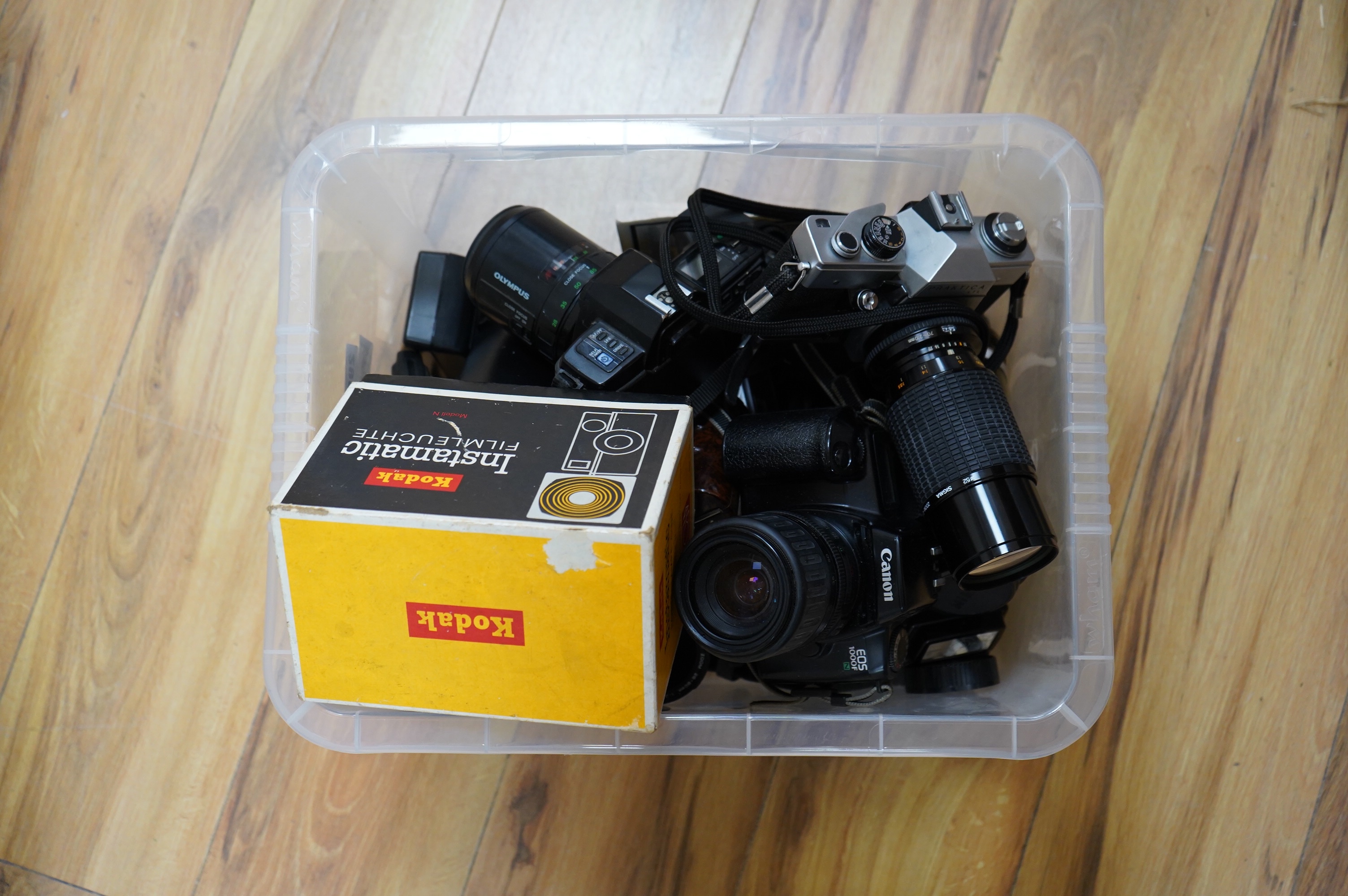 A quantity of cameras and lenses to include a Praktica LTL, Olympus OM77AF, Canon 1000F and Tamron 70-150 lens. Condition - varies